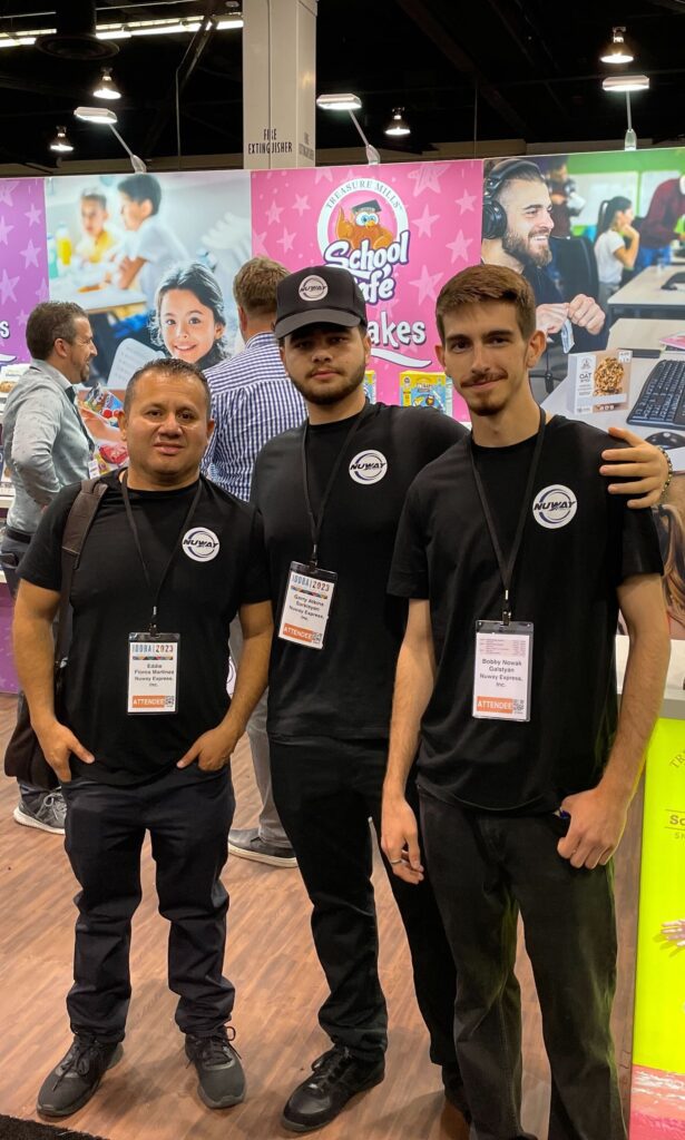 Three men in black shirts and a white hat