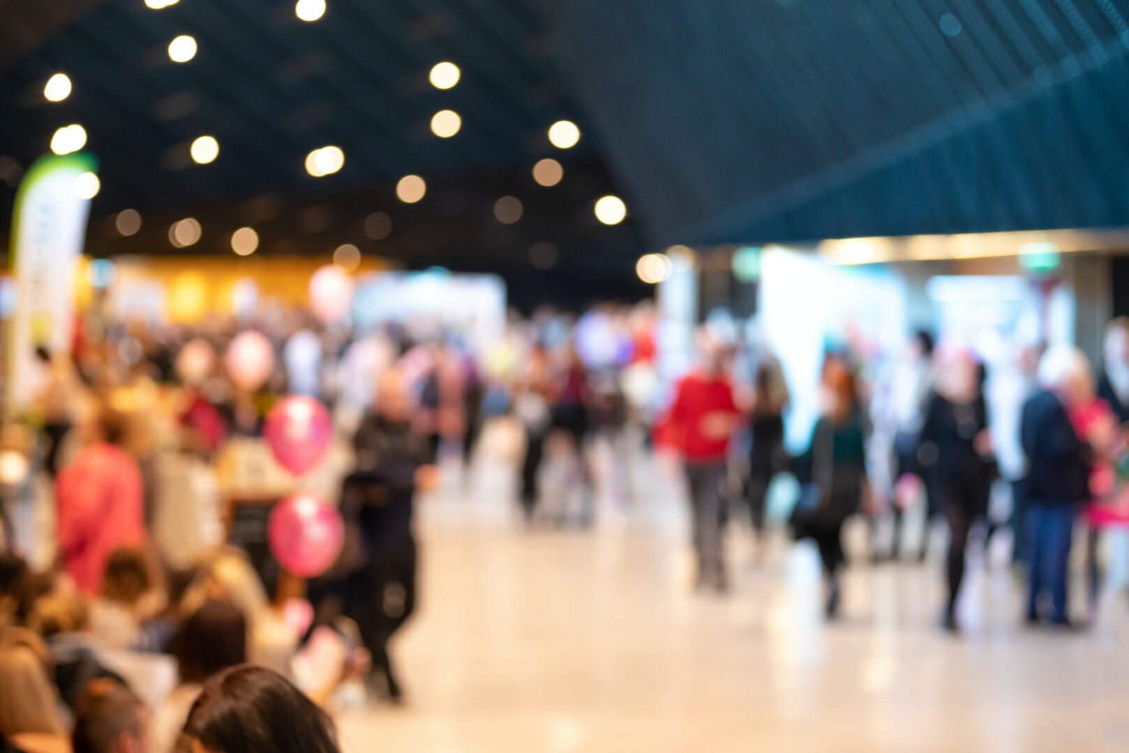 A crowd of people walking in an indoor area.