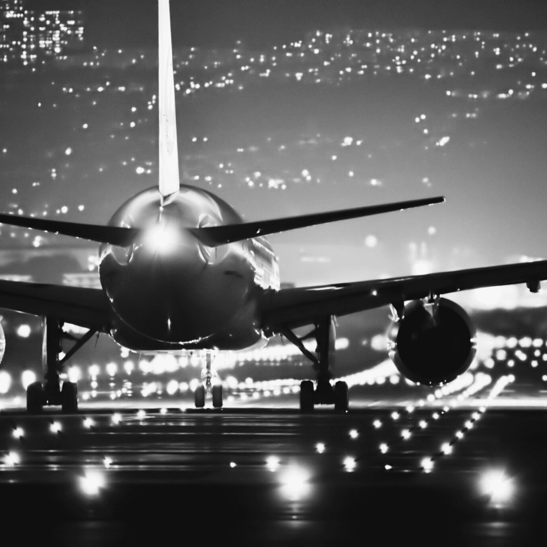 A black and white photo of an airplane at night.
