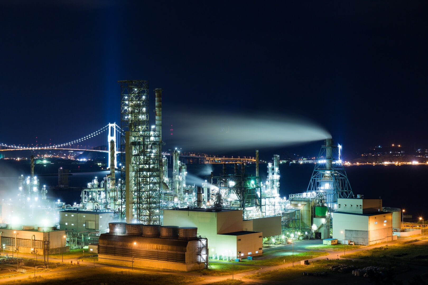 A large oil refinery at night with lights on.